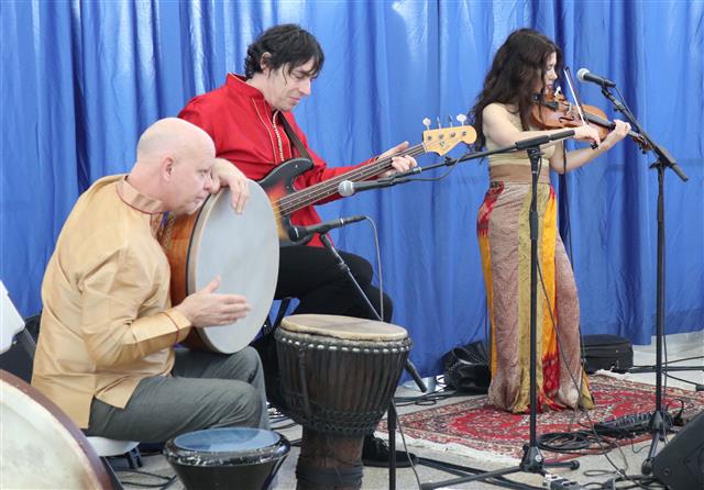 Band Opium Moon performing in a terminal, the band consist of a Violin, a Santoor, ancient percussion, and a fretless bass.