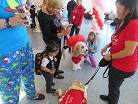 Candid photo of PUP's program volunteers and guests enjoying adorable puppies.